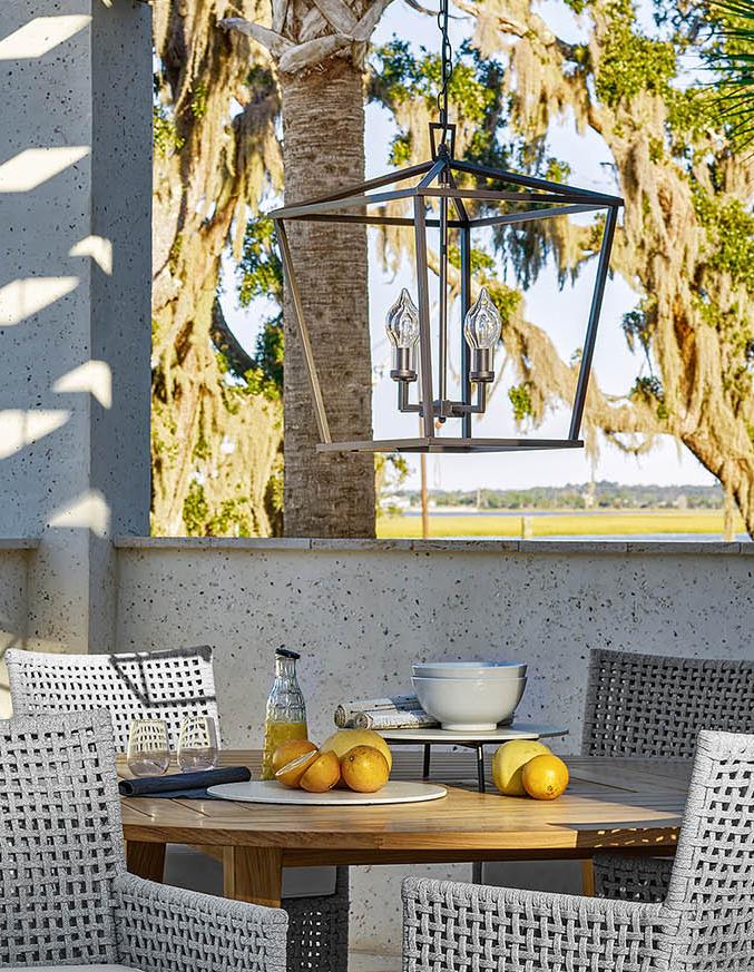 wooden table and four chairs on outdoor patio with fruit on table