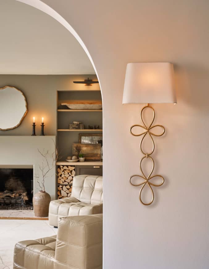 natural brass wall sconce above kitchen shelf with dishes