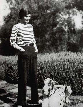 Coco Chanel and her Great Dane standing in a garden, 1930