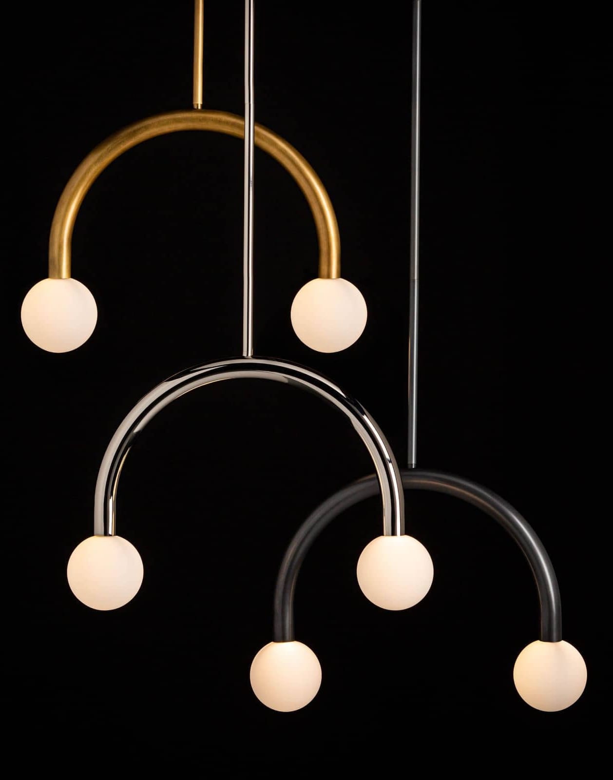 Bauhaus inspired curved pendants in natural brass, polished nickel, and oil rubbed bronze finishes