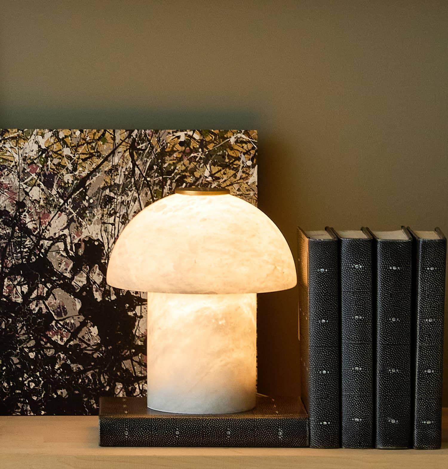 Alabaster uplight beside black books