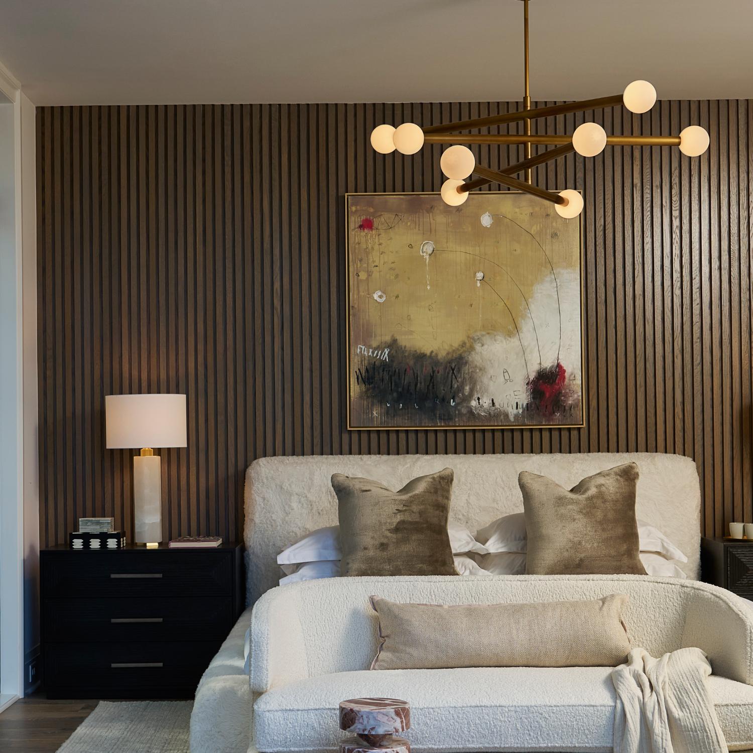 bedroom with wood slat accent wall bed and chandelier hanging above bed