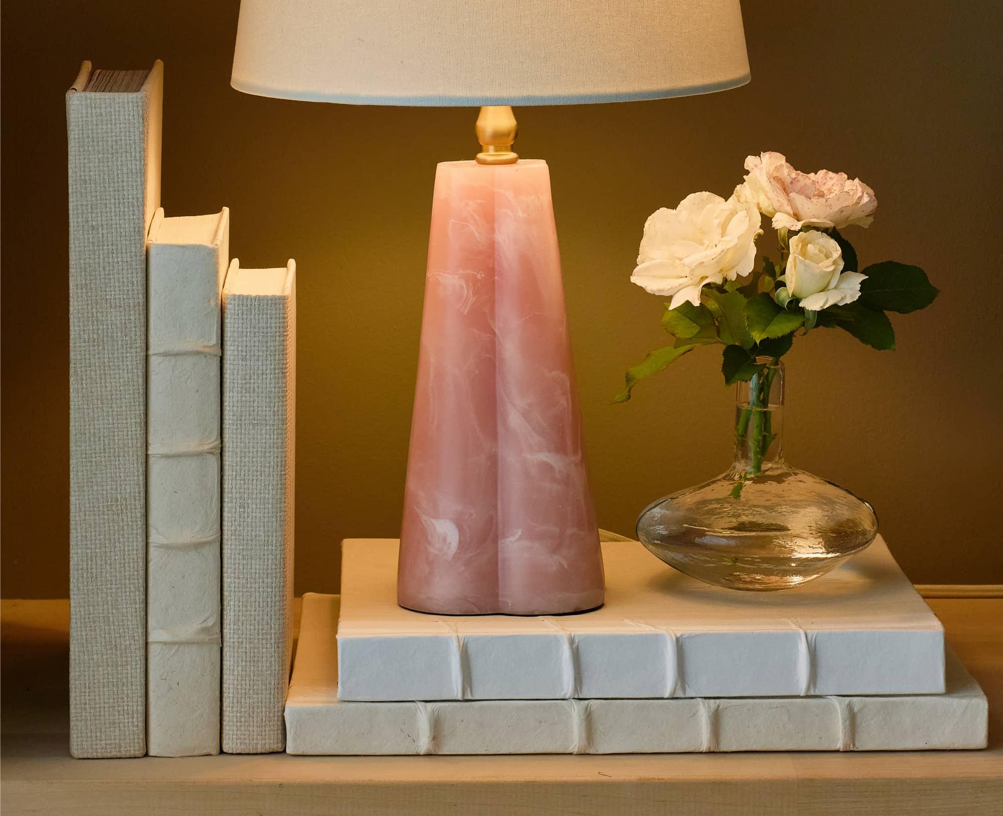 White books holding pink mini lamp