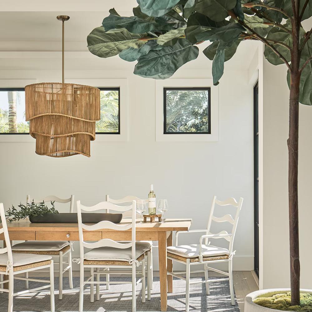 dining room with a rectangular table white chairs and a large potted plant