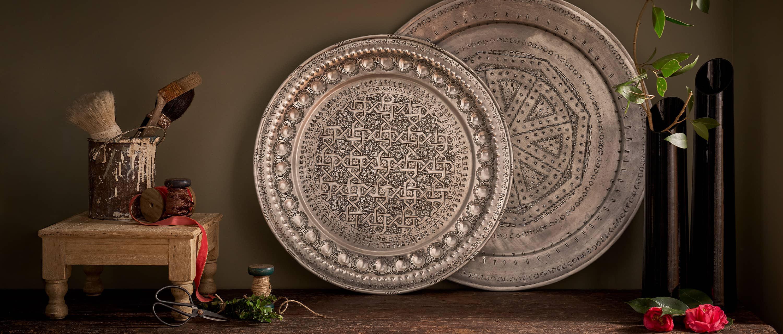 still life with vintage metal plate and black vases