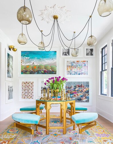 Bright and colorfulwhimsical room with a gold and blue table and chairs, and a hanging molten glass chandelier