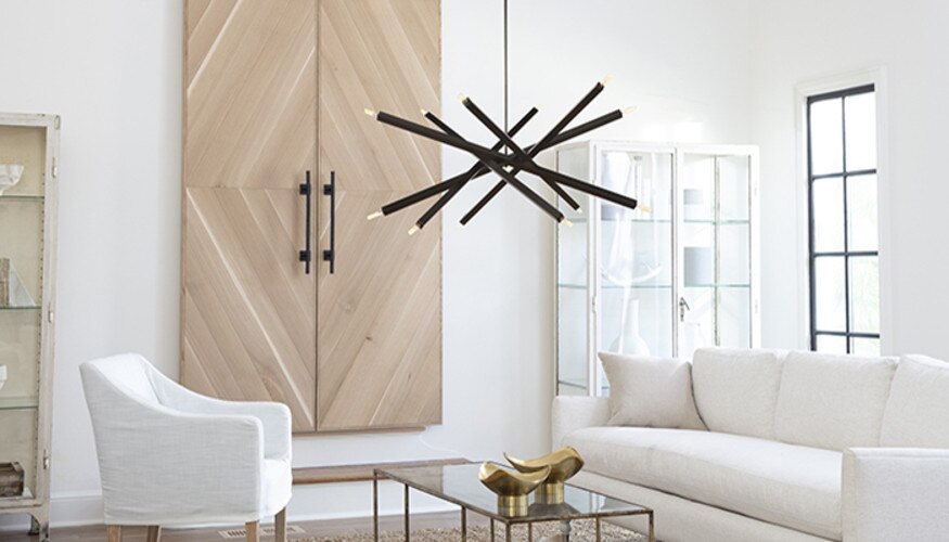 Living room with a white couch and chair, a glass coffee table, and a modern black chandelier